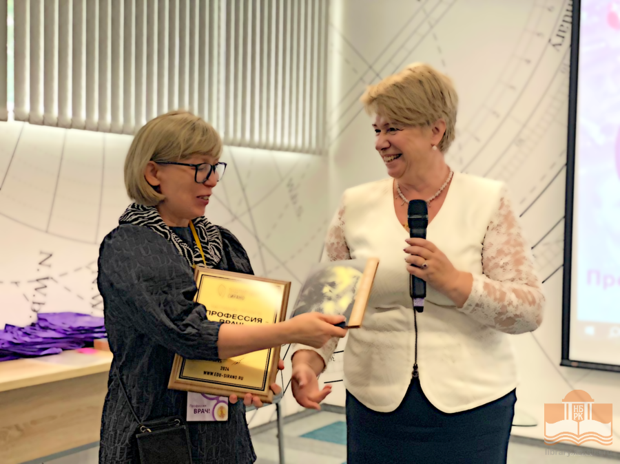 Надежда Леонидовна Власова вручает библиотеке книги в дар